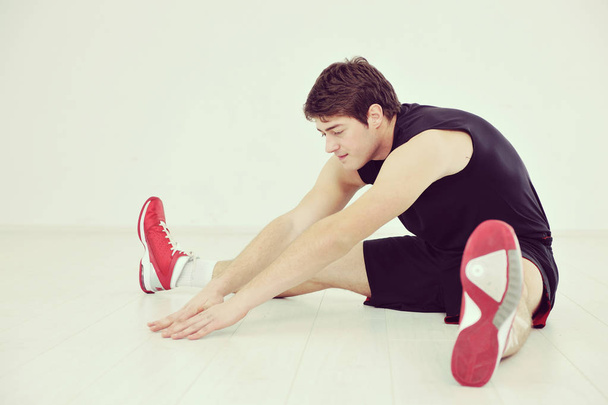 jonge man in fitness sport club oefening met gewichten en ontspannende duo-tone - Foto, afbeelding
