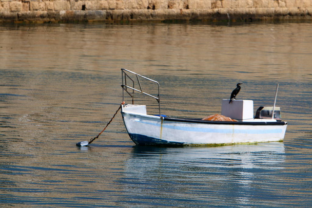 am pier in der stadt akko liegt ein kleines fischerboot  - Foto, Bild