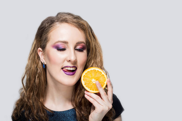 Happy young woman holding oranges halves - Fotografie, Obrázek