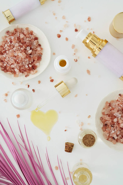 φυσικό skincare προϊόντα ομορφιάς με ροζ palm φύλλο σε λευκό φόντο - Φωτογραφία, εικόνα
