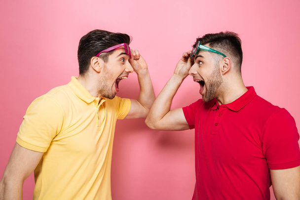 Portrait of a surprised gay male couple in sunglasses - Photo, Image