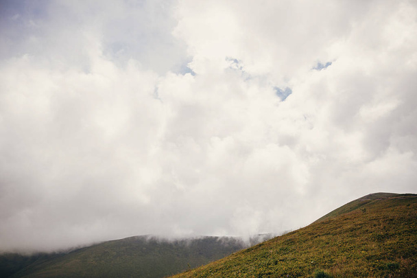 krásný kopec s trávou na mlžné mraky a mlha, Slunečné hory. krajinných scenérií kopců v ranním světle, s mraky. Letní cestování - Fotografie, Obrázek