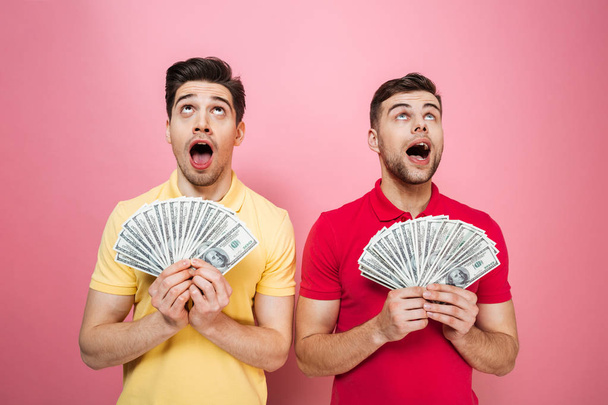 Portrait of an excited gay male couple holding money - Фото, зображення