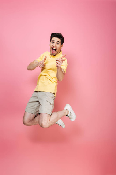 Full length portrait of an excited young man jumping - Φωτογραφία, εικόνα