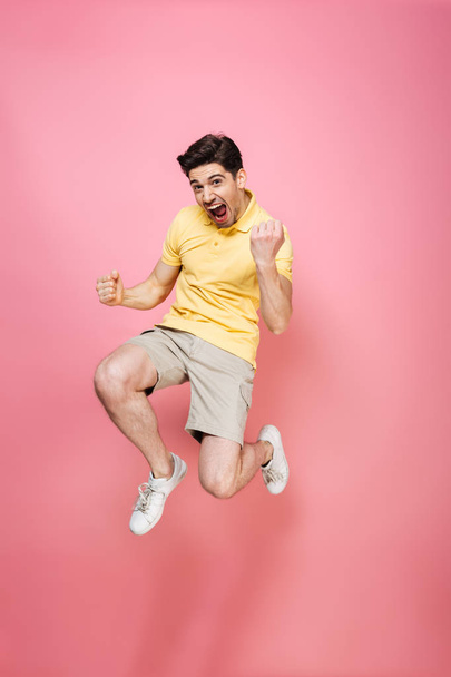 Full length portrait of an excited young man jumping - Fotoğraf, Görsel