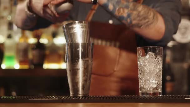 Volwassen barman met tatoeages op handen bereidt cocktails, close-up - Video