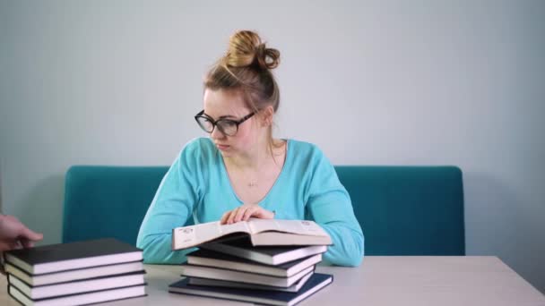 Portrait of clever student with open book reading it in college library - Séquence, vidéo