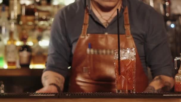 Cantinero está decorando un vaso con cóctel de pie en un estante de bar, primer plano
 - Imágenes, Vídeo