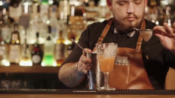 Близкий выстрел в руки барменов, мужчина наливает коктейль из шейкера в стакан
 - Кадры, видео