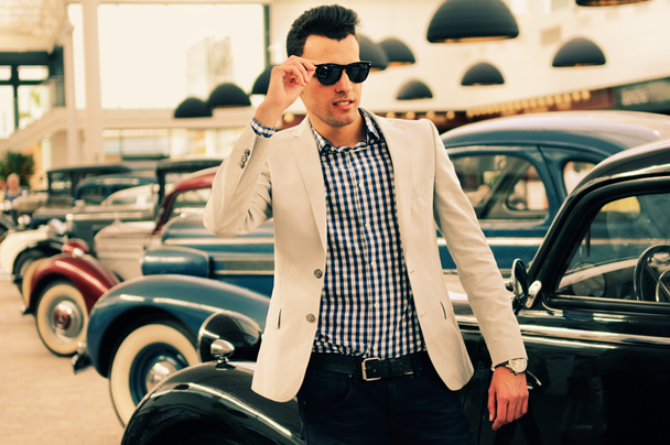 Attractive man wearing jacket and shirt with old cars - Photo, Image