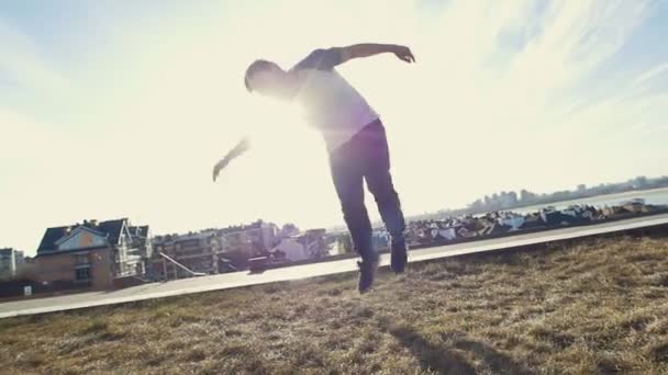 Genç erkek Parkour şaşırtıcı tricker jumper gerçekleştirir çevirir, siluet - Video, Çekim