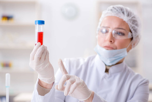 Γυναίκα γιατρός ελέγχει δείγματα αίματος στο εργαστήριο - Φωτογραφία, εικόνα