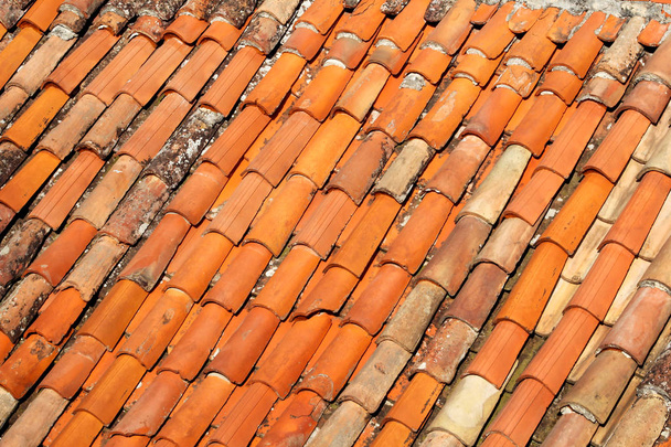 Parte di piastrelle sul tetto di un edificio, primo piano. Un tetto di terracotta piastrellata rossa. Le tegole arancioni, mappe e texture. Texture di piastrelle. Sfondo con parte del tetto. Righe di mattoni del tetto
. - Foto, immagini