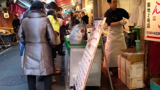 Ruokakojun omistaja viihdyttää asiakkaitaan Tsukiji Marketissa, Tokiossa, Japamissa
 - Materiaali, video