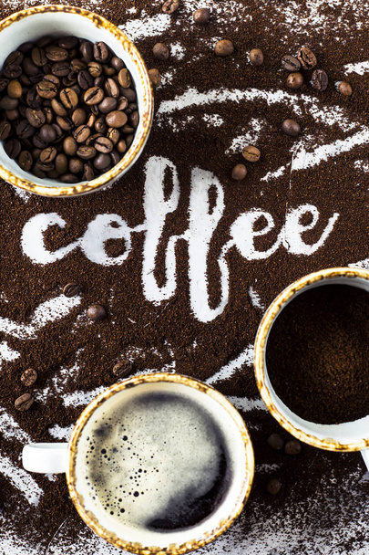Une tasse de café chaud frais avec mousse, une tasse de moulu et une tasse de grains de café à côté du mot "café" écrit sur le café moulu
, - Photo, image