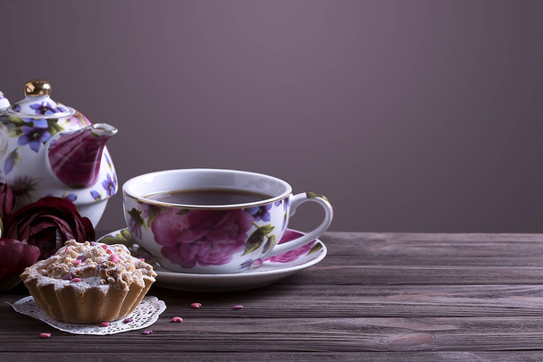 Tetera taza de té y pastel en mesa de madera marrón
. - Foto, imagen