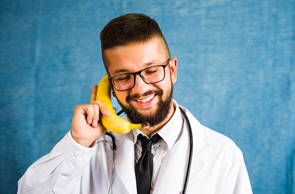 Lustiger Arzt mit Banane als Telefon - Foto, Bild