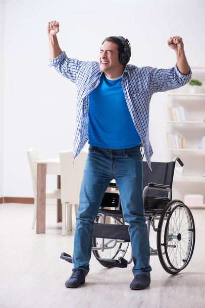 Disabled man listening to music in wheelchair - Photo, Image