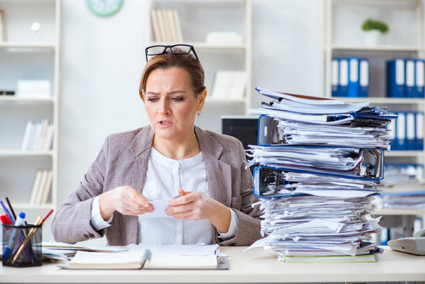 Businesswoman very busy with ongoing paperwork - Фото, зображення