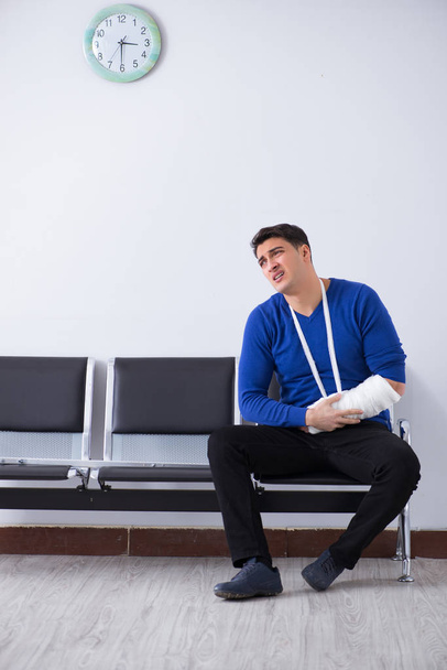 Verzweifelter Mann wartet mit gebrochenem Bein auf seinen Termin im Krankenhaus - Foto, Bild