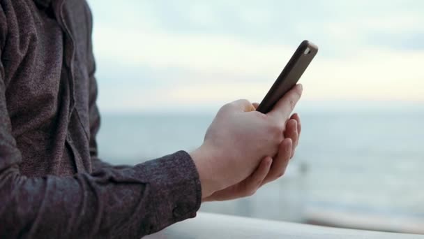 Close-up shot van een mans handen, hij werkt in een internetbedrijf op een telefoon - Video