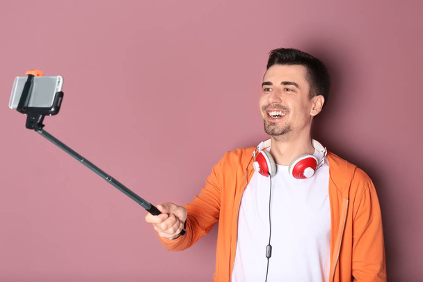 Handsome man taking selfie against color background - Fotoğraf, Görsel