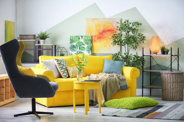 Stylish living room interior with comfortable sofa and armchair - Fotoğraf, Görsel