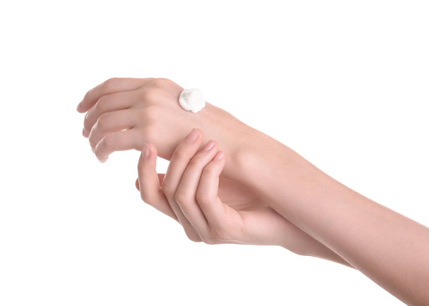 Young woman applying hand cream against on white background - Foto, imagen