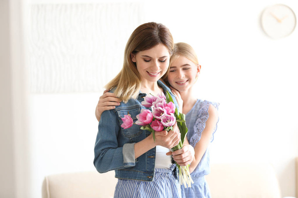 Teenager-Tochter gratuliert glücklicher Frau zum Muttertag zu Hause - Foto, Bild