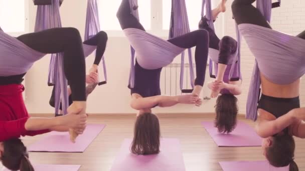 Grupo de personas haciendo asanas aéreas de yoga en el gimnasio
 - Imágenes, Vídeo