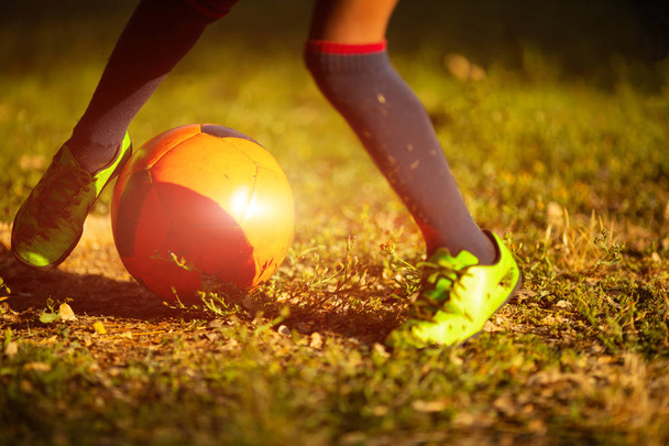 Close up view of player legs and ball on green grass outdoors background - Photo, image