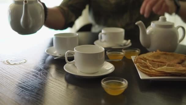 クローズ アップのショット、マンの手、テーブルで朝食を済ませ、お茶を注ぐ彼は - 映像、動画