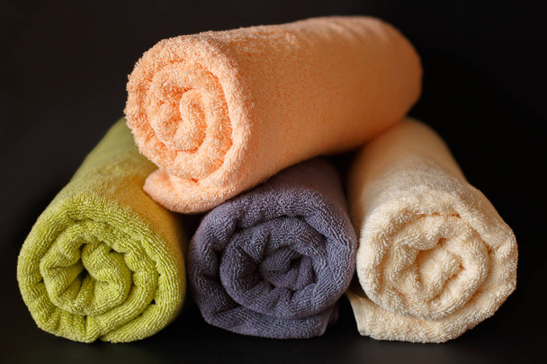 Rolled clean towels on black background. Laundry day. - Photo, Image