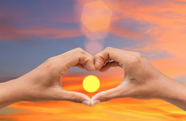 kéz alkotó egy szív alakú szóközzel naplemente fény és másol a szöveg hozzáadása - Fotó, kép