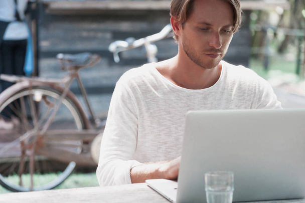 Young male freelancer sitting in cafe working in laptop - Фото, зображення