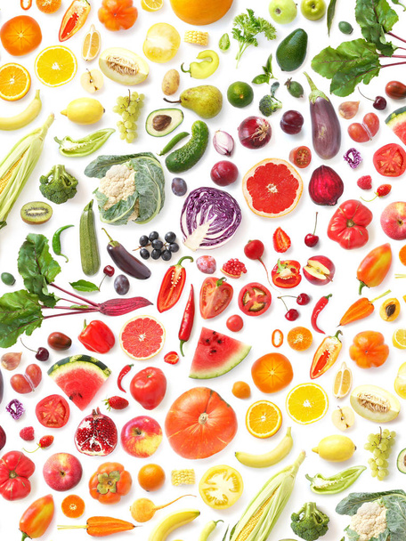 close-up photo of fresh fruits and vegetables set in rainbow colors on white table background - Photo, image