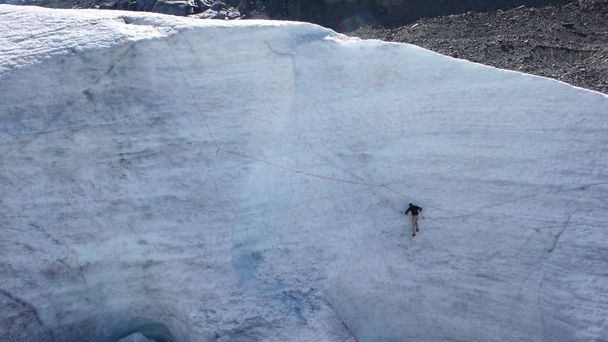 jovem guia de montanha masculino treinando habilidades de gelo e corda para escalar uma montanha em uma geleira em um belo dia de verão
 - Foto, Imagem