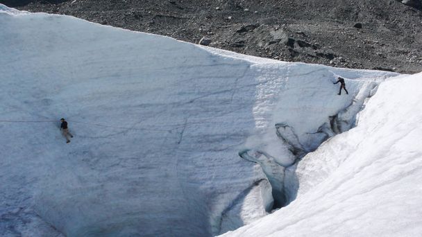 zwei Bergführerkandidaten, die auf einem Gletscher in den Schweizer Alpen Eisbeil und Seil trainieren - Foto, Bild