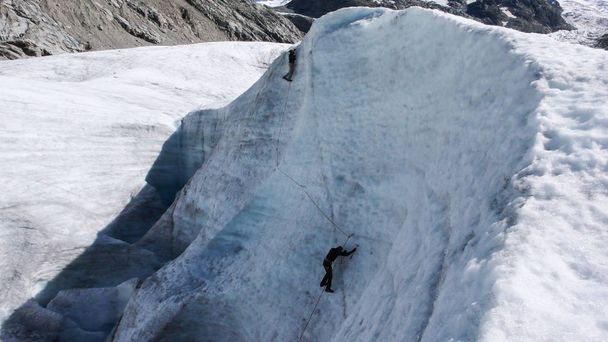 dois candidatos de guia de montanha treinando habilidades de machado de gelo e corda em uma geleira nos Alpes Suíços
 - Foto, Imagem