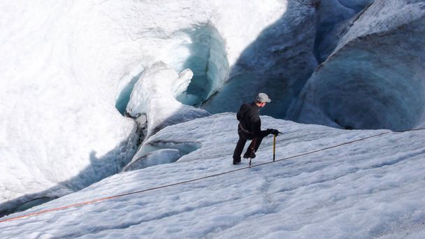 un guía de montaña candidato a la formación de hacha de hielo y habilidades de cuerda en un glaciar en los Alpes suizos
 - Foto, imagen