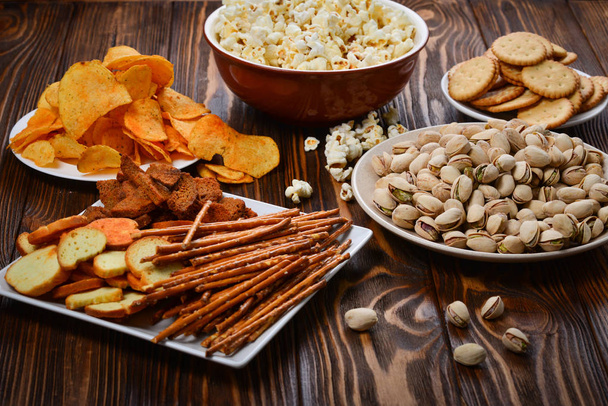 Snacks on a wooden background. Space for text or design.  - Photo, Image