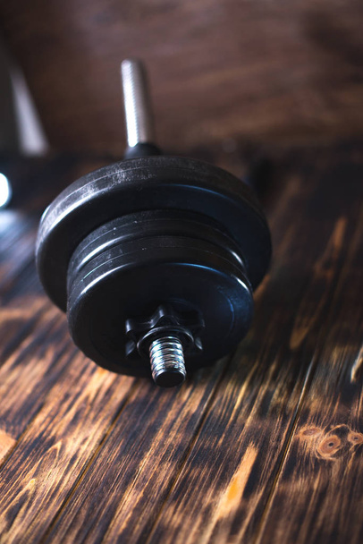 Dumbbells on a wooden dark background. Concept of playing sports - Foto, immagini
