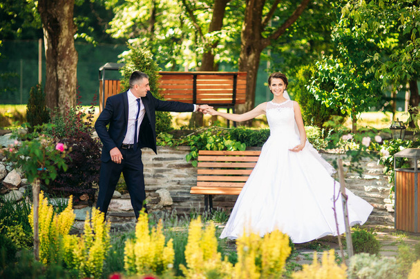 Novomanželé tančí jejich svatební tanec v parku - Fotografie, Obrázek