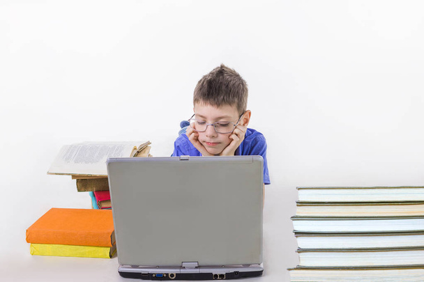 Portrét roztomilý kluk sedí s knihami a psaní na klávesnici notebooku - Fotografie, Obrázek