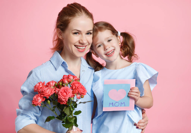 concept of mother's day. mom and child girl with flower on colored backgroun - Fotoğraf, Görsel