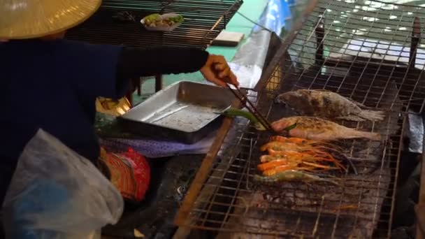 Thai nainen perinteisessä kankaassa ruoanlaitto iso katkarapuja grilli tulipalo veneen kelluva markkinoilla, Bangkok
. - Materiaali, video