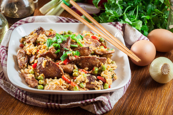 Fried rice with chicken and vegetables served on a plate - Photo, Image