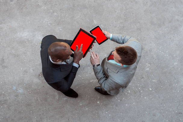 Kaksi miestä tilalla tabletti ja keskustella liiketoiminnan ulkona
 - Valokuva, kuva
