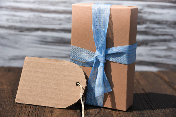подарункова коробка з бантом на дерев'яному столі вид спереду
 - Фото, зображення