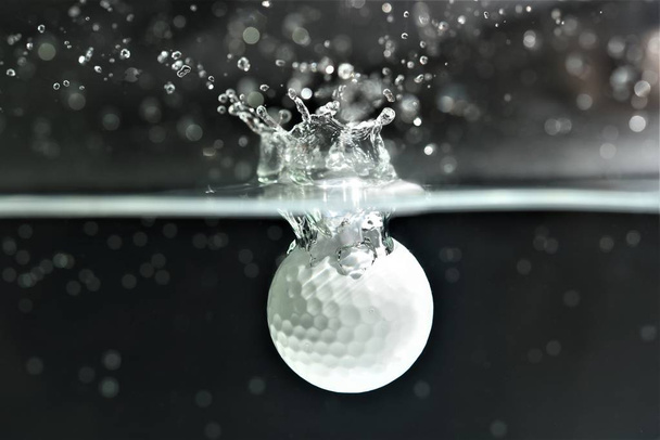 golf ball fall down into water dark background - Zdjęcie, obraz